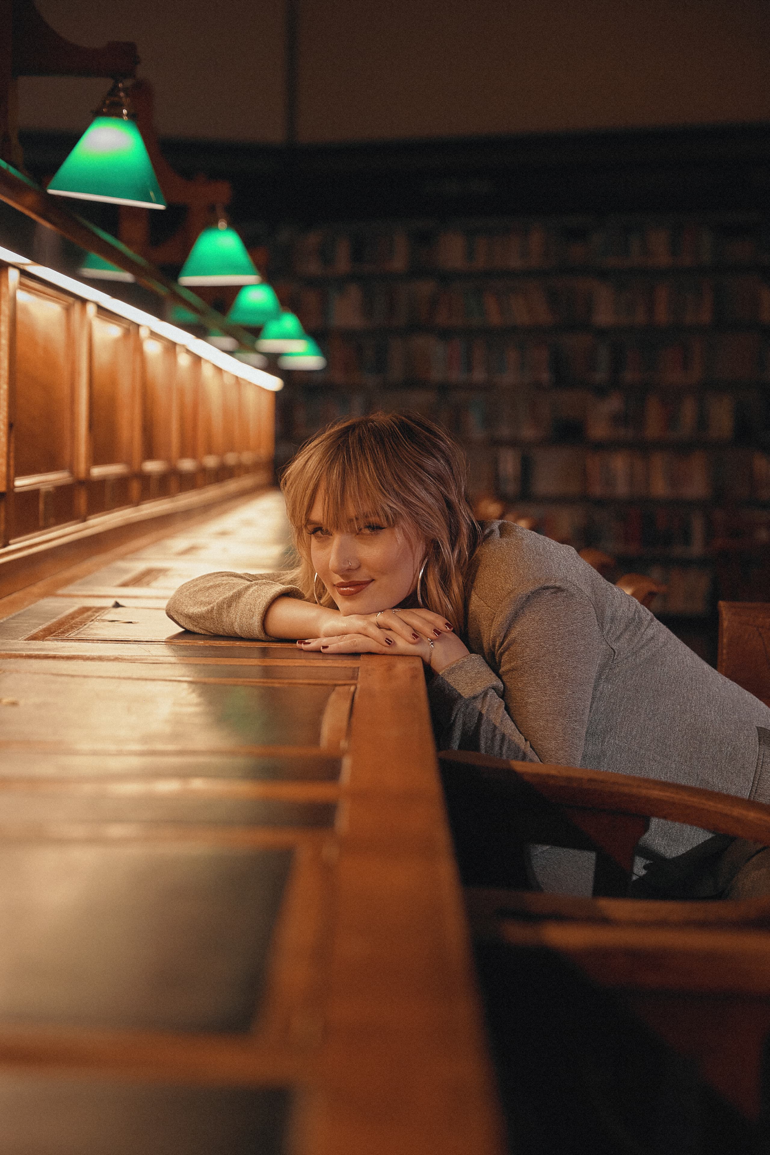 Gretta Ray resting on a timber reading desk inside the State Library of Victoria during an Amazon Music live session shoot