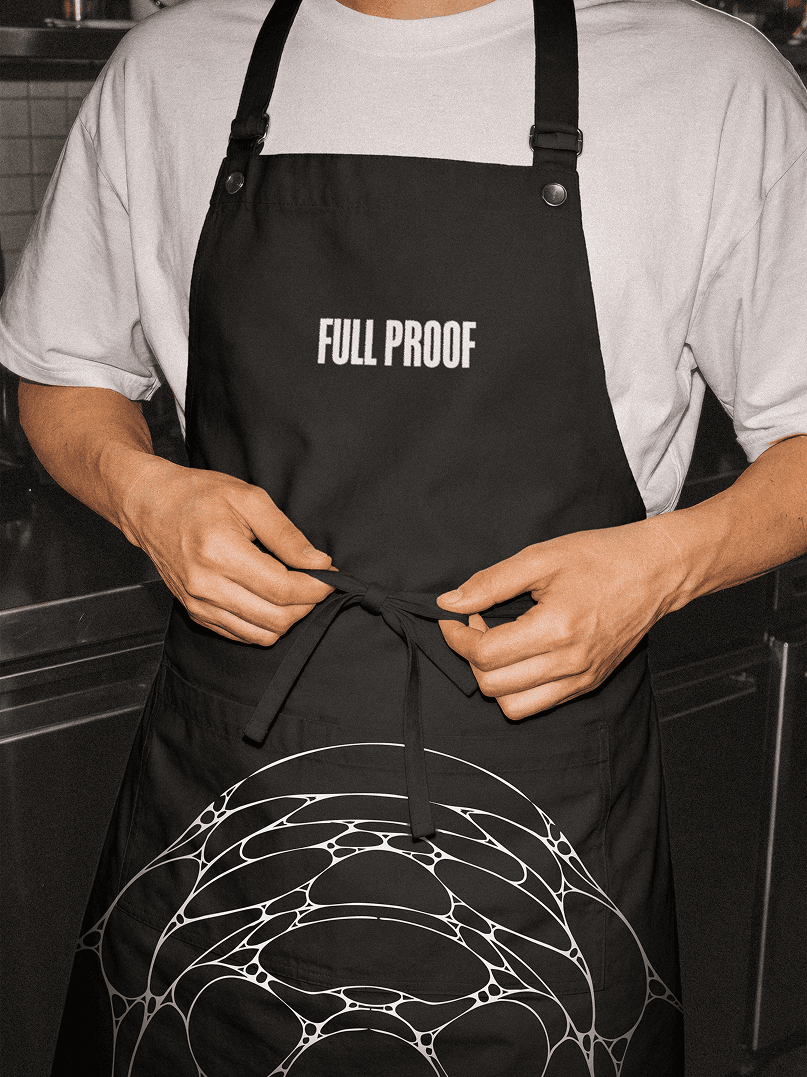 <p>Full Proof branded apron lockup showing logo in hospitality setting</p>